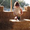 woman cutting straw bales with chainsaw